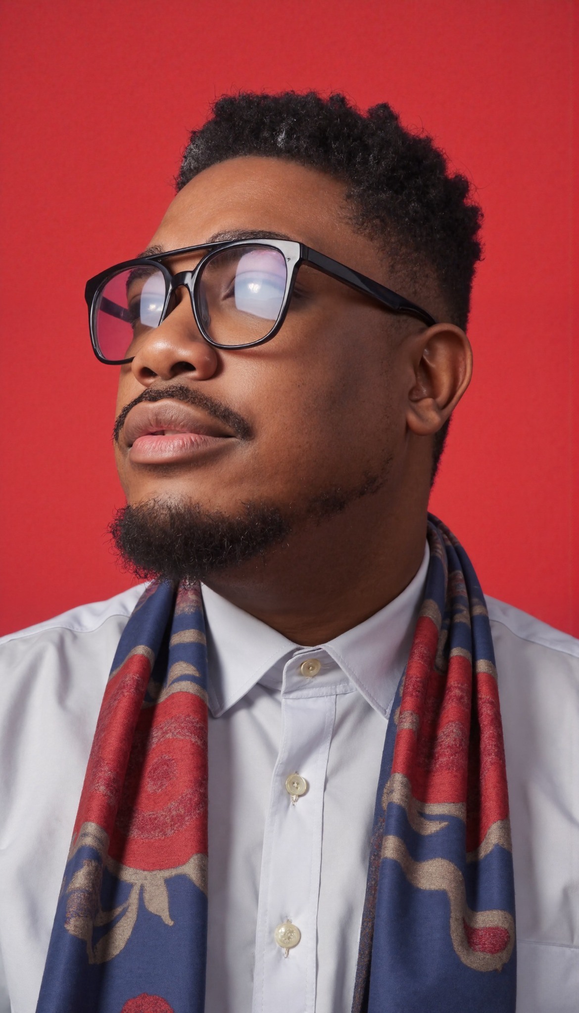 Portrait of Kirk Perry against a vivid red background